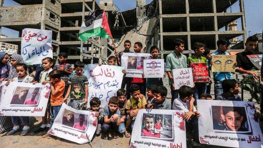 Palestinian children demonstrate on July 15, 2018, outside a building in Gaza City that was struck in an Israeli air raid the day before.