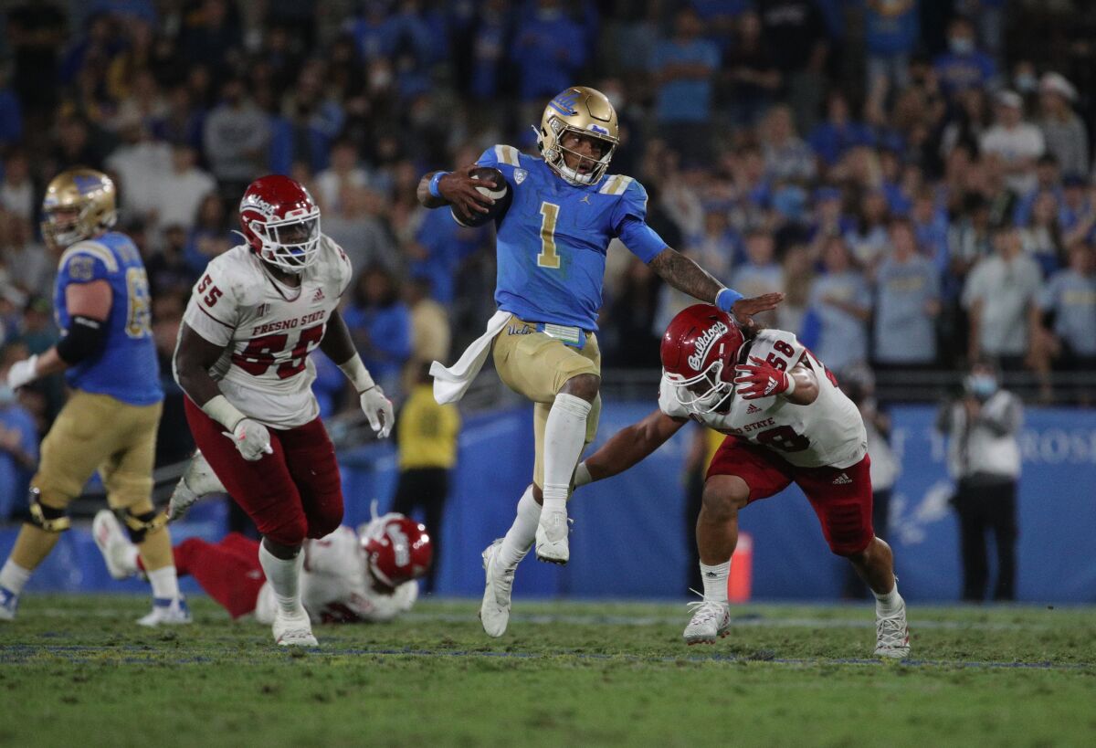 UCLA quarterback Dorian Thompson-Robinson eludes a tackle attempt by Fresno State linebacker Tyson Maeva.