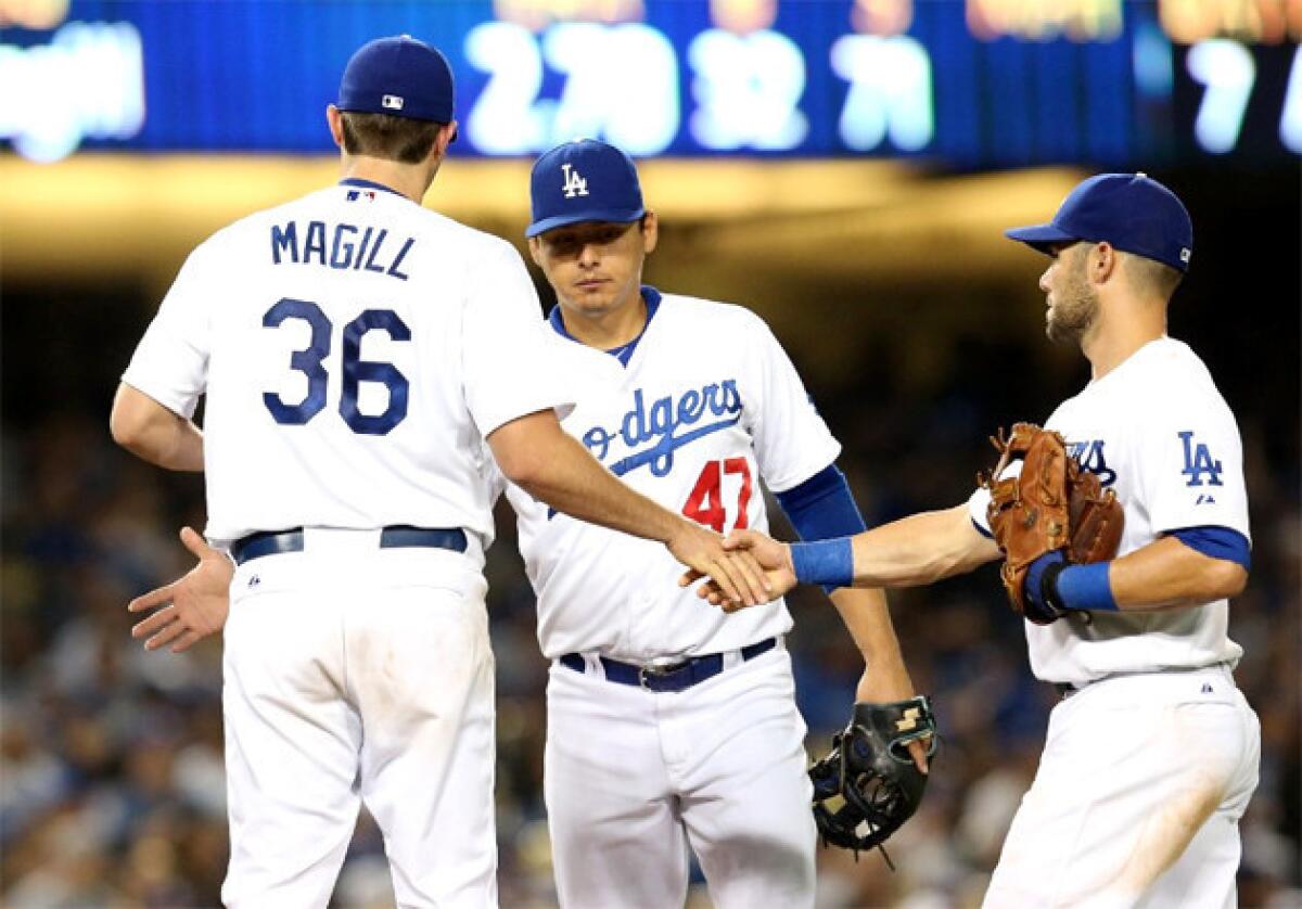 Dodgers pitcher Matt Magill is congratulated by Luis Cruz (47) and Skip Schumaker as he is removed from the game in the seventh inning after his first major-league start.