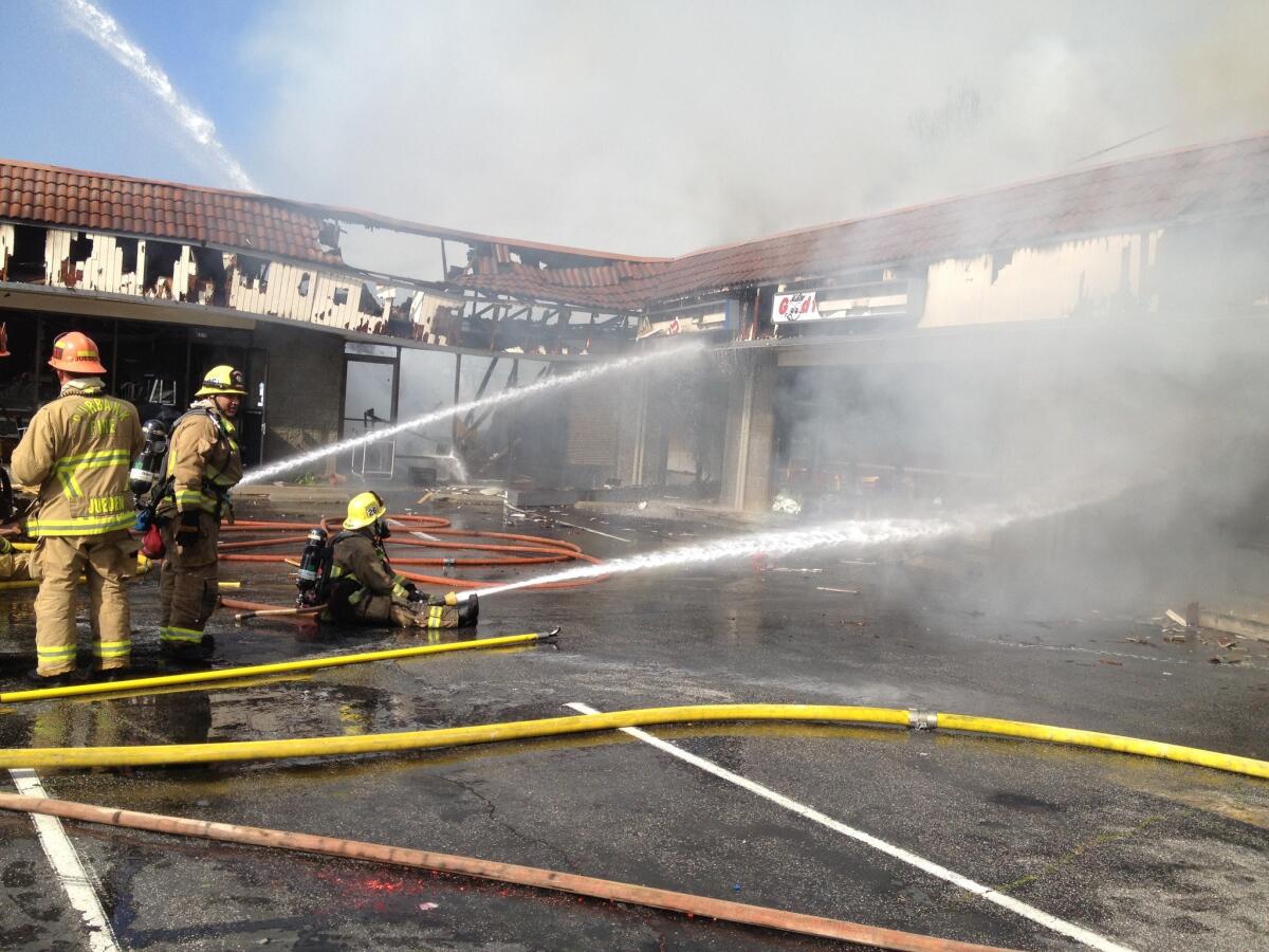 Firefighters hose down a blaze that broke out in a strip mall on Glenoaks Boulevard Monday, Feb. 10, 2014.