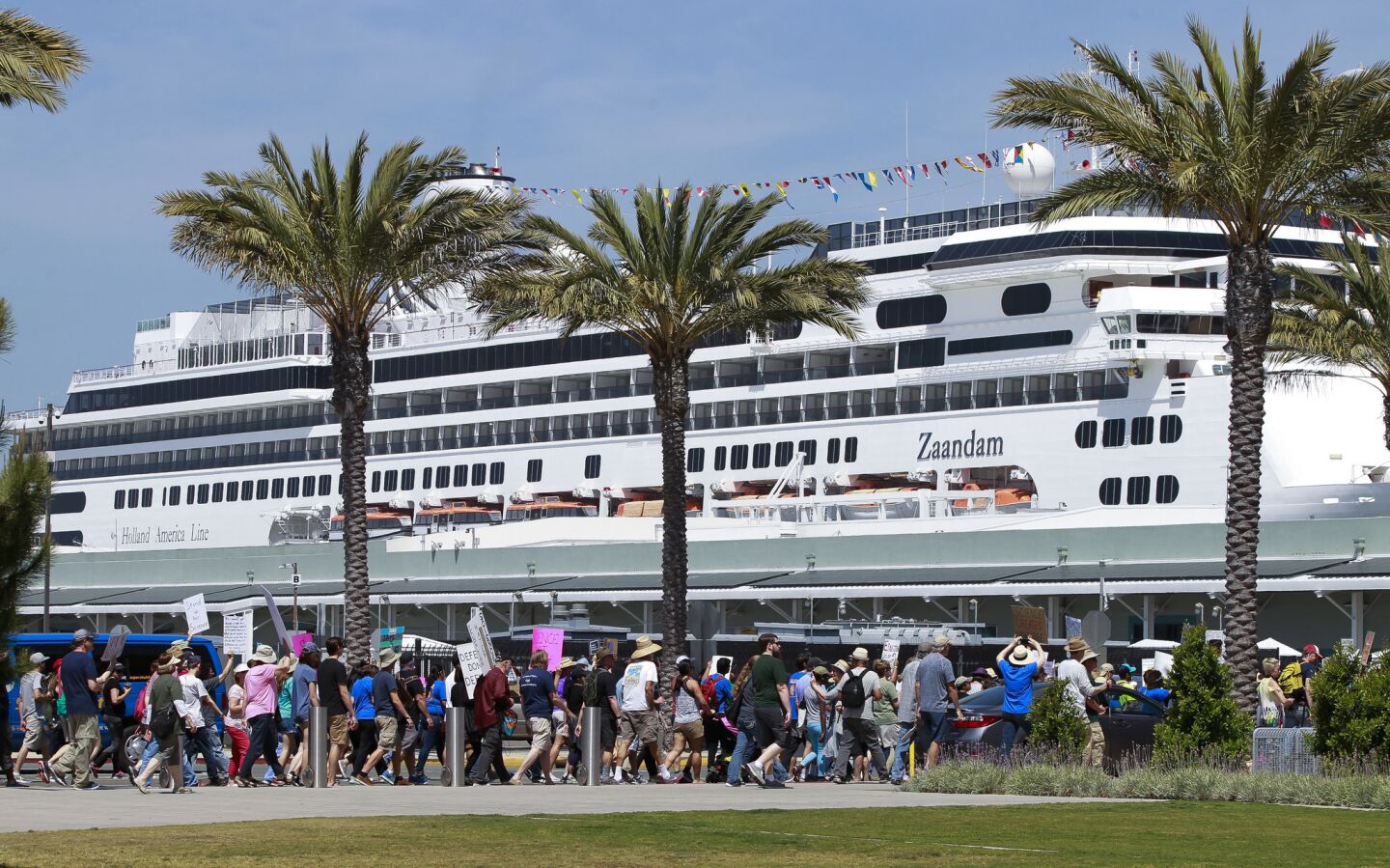 People participating in the March for Science walk past a docked cruise ship on North Harbor Drive.
