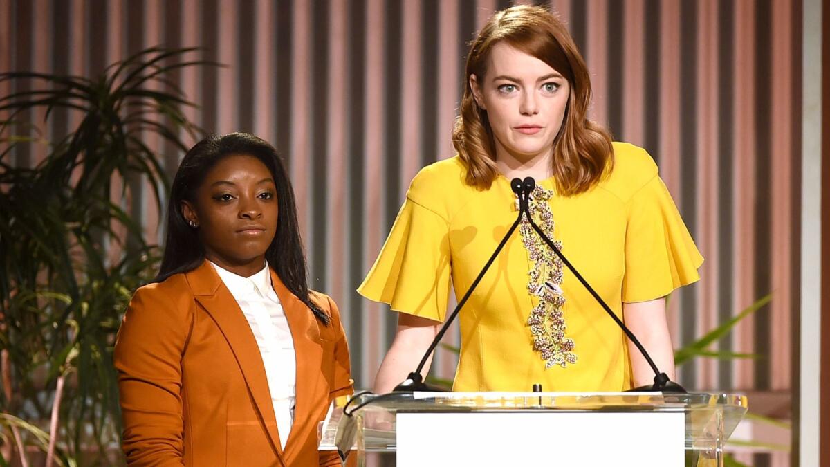 Honoree Simone Biles, left, and Emma Stone appear onstage during the Women in Entertainment Breakfast at Milk Studios.