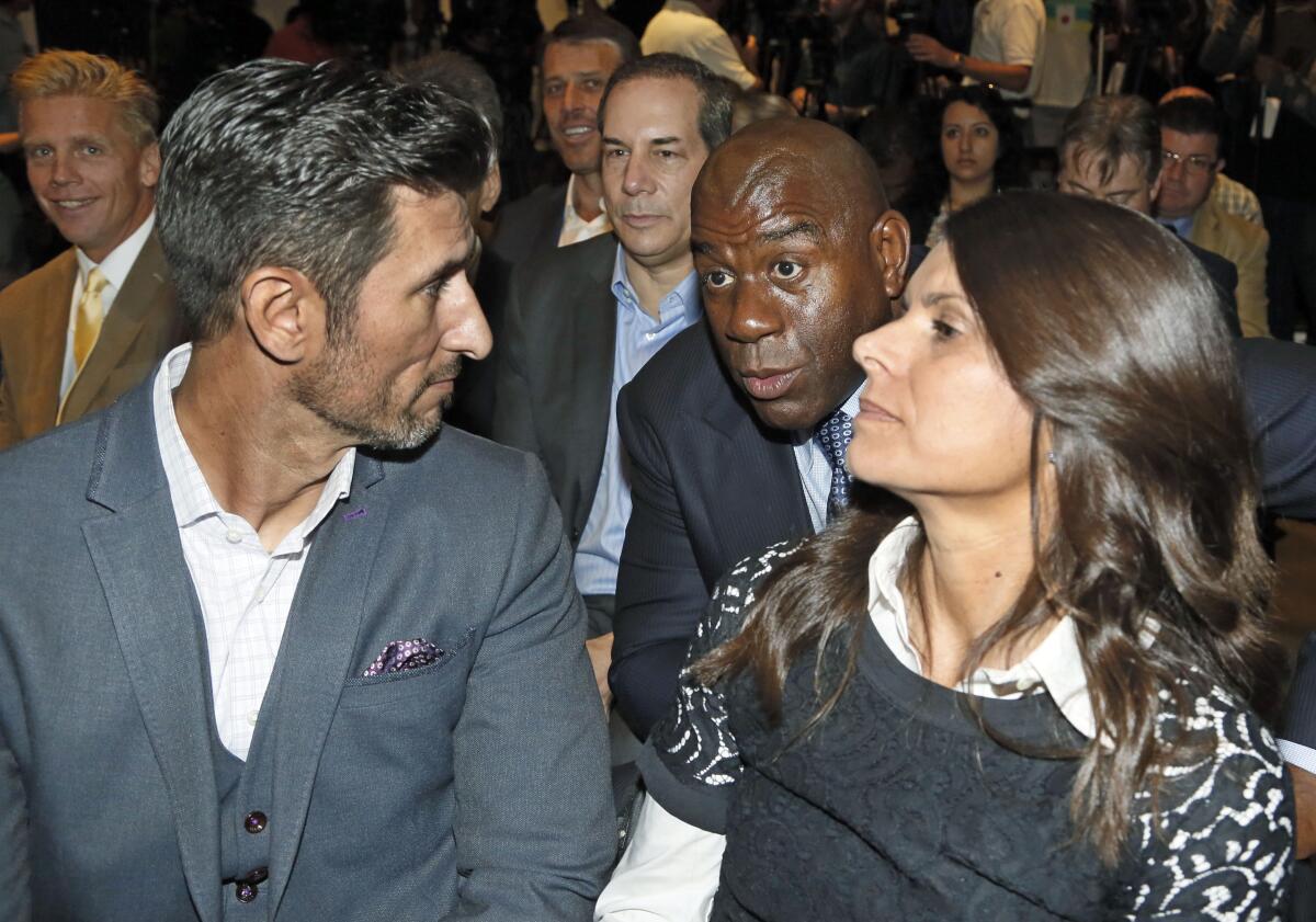 Mia Hamm attends a news conference with husband Nomar Garciaparra, left, and Magic Johnson on Oct. 30, 2014. 