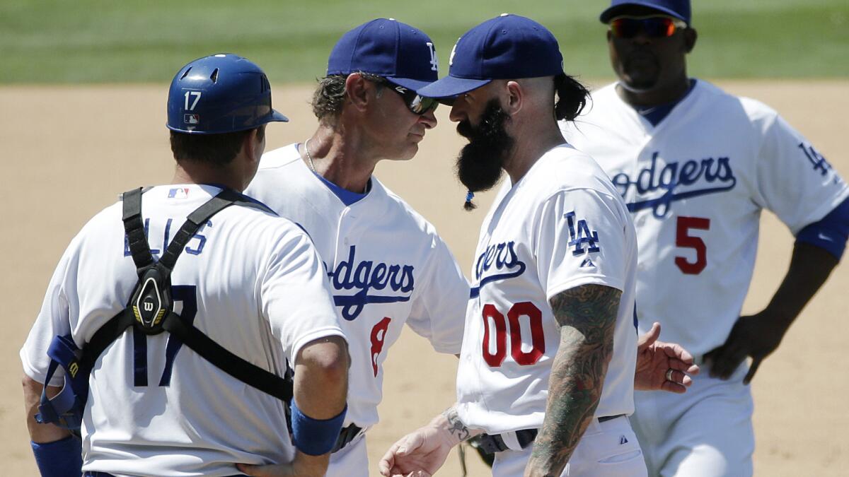 Dodgers Manager Don Mattingly, second from left, pulls reliever Brian Wilson, second from right, out of the game as catcher A.J. Ellis, left, and third baseman Juan Uribe look on during the eighth inning of Wednesday's 5-4 loss to the Cleveland Indians.