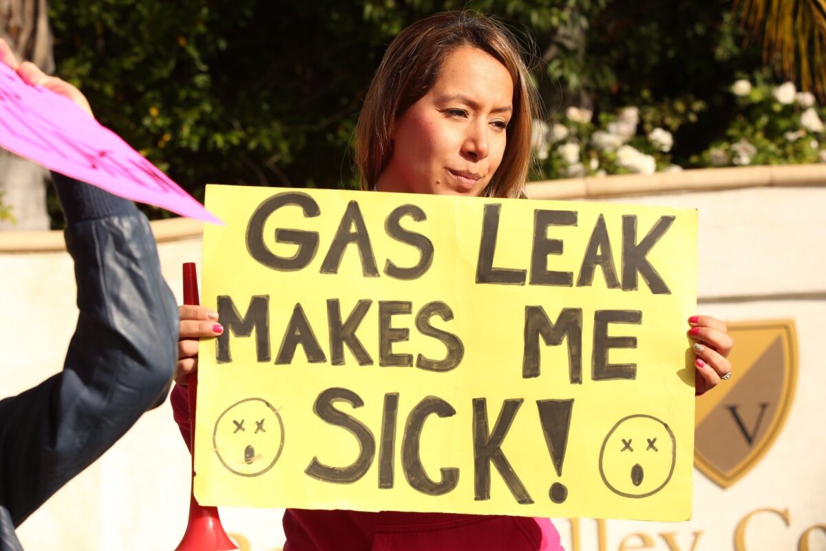 Parent Rocio Arreola holds up a protest sign in Porter Ranch on Dec. 11.