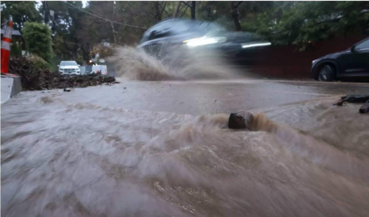 Un automóvil circula por una calle llena de agua 
