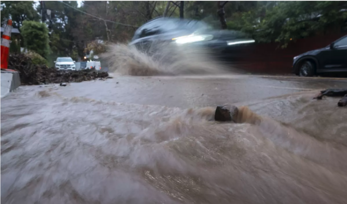 Un automóvil circula por una calle llena de agua