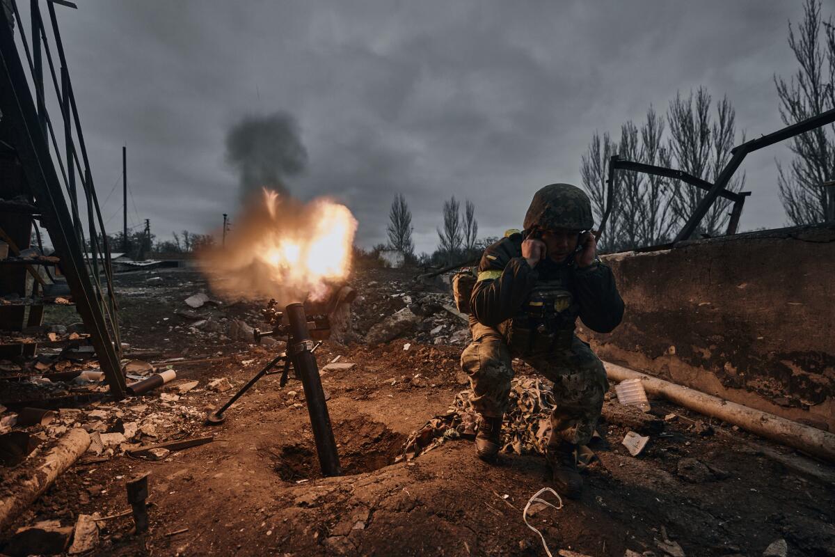 A Ukrainian soldier fires a mortar at Russian positions