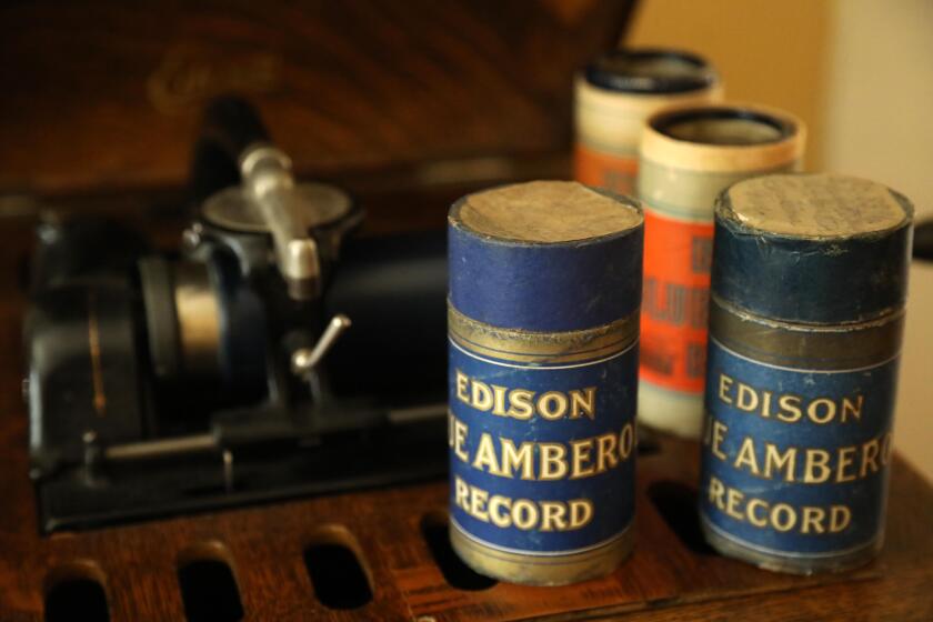 SANTA BARBARA, CA - NOVEMBER 10, 2020 - Four Edison Blue Amberol cylinder records, right, can be played on a Edison Amberola phonograph, background, in the home of David Seubert, curator for Performing Arts Collection at UC Santa Barbara Library, in Santa Barbara on November 10, 2020. Seubert runs the Cylinder Audio Archive at the university and under his guidance, 10,000 of these cylinders, the oldest commercial music formate, have been digitized and made available for streaming and download. The Cylinder Audio Archive is a free digital collection maintained by the University of California, Santa Barbara Library with streaming and downloadable versions of over 10,000 phonograph cylinders manufactured between 1893 and the mid-1920s. (Genaro Molina / Los Angeles Times)