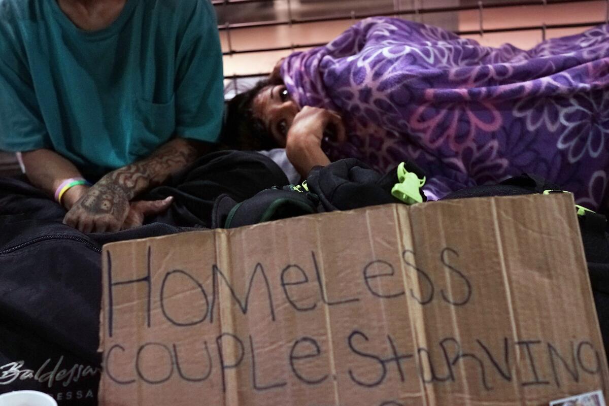 A homeless couple in New York is shown. The Heritage Foundation undermines support for government anti-poverty programs by implying that they're either ineffective or unnecessary.