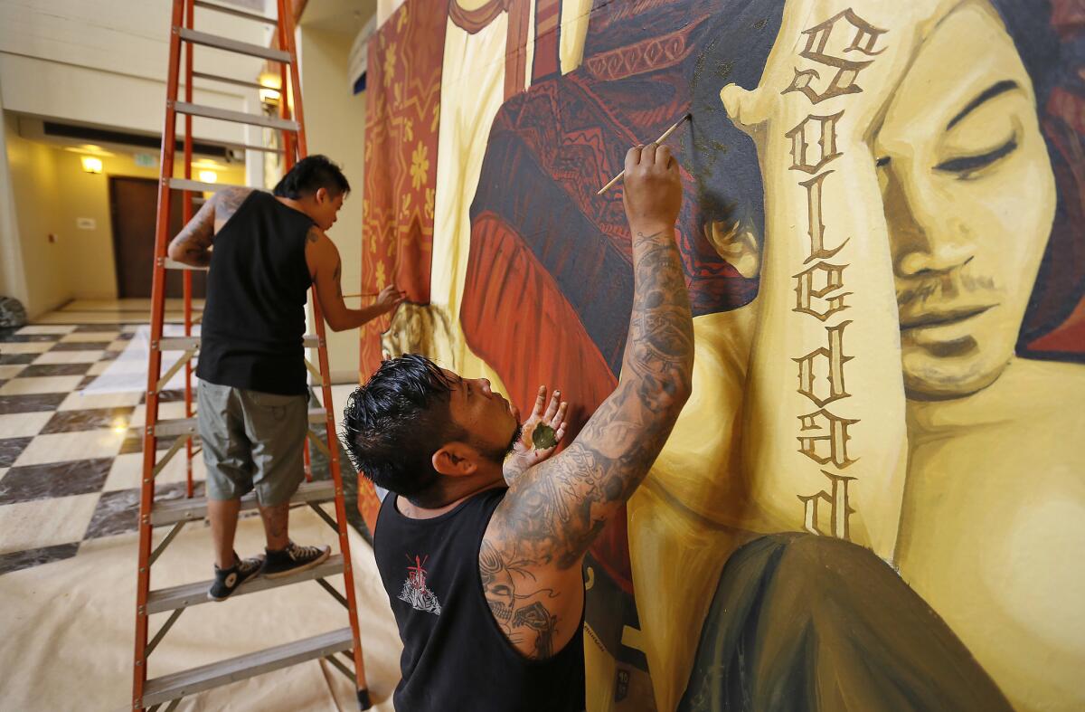 Canul, in the foreground, and Cosijoesa Cernas putting finishing touches on their project. (Al Seib / Los Angeles Times)