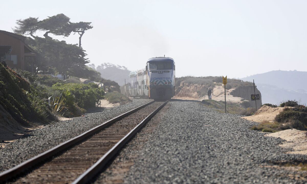 A Coaster train heads north along the bluffs in Del Mar where a fence will be installed by North County Transit District.