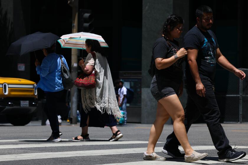 Los Angeles, CA - July 28: People are seen crossing the street in downtown on Sunday, July 28, 2024 in Los Angeles, CA. (Dania Maxwell / Los Angeles Times)