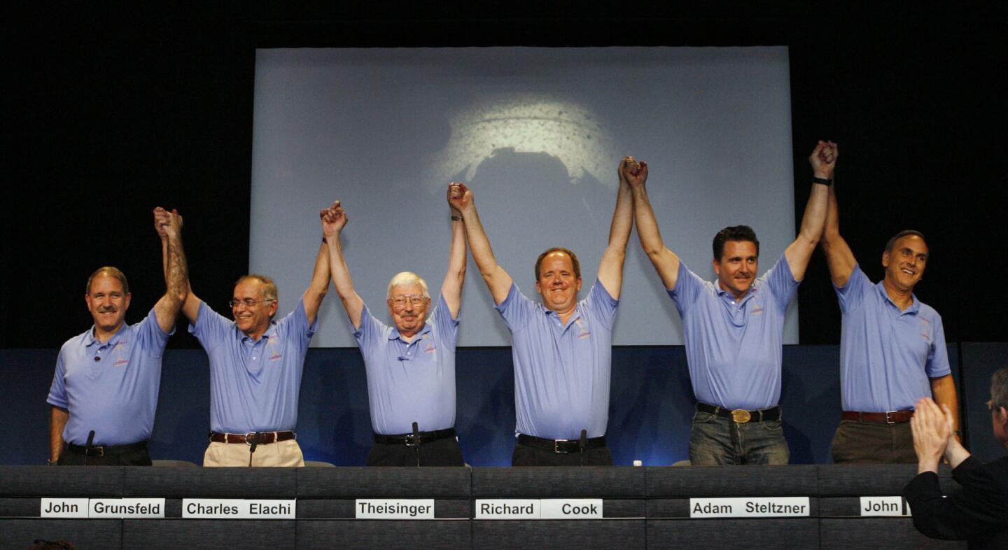 A proud lead team of John Grunsfield, Charles Elachi, Pete Theisinger, Richard Cook, Adam Steltzner and John Grotzinger, triumphantly raise their hands at JPL at the post landing press conference with the principals who successfully landed the Mars Rover Curiosity.
