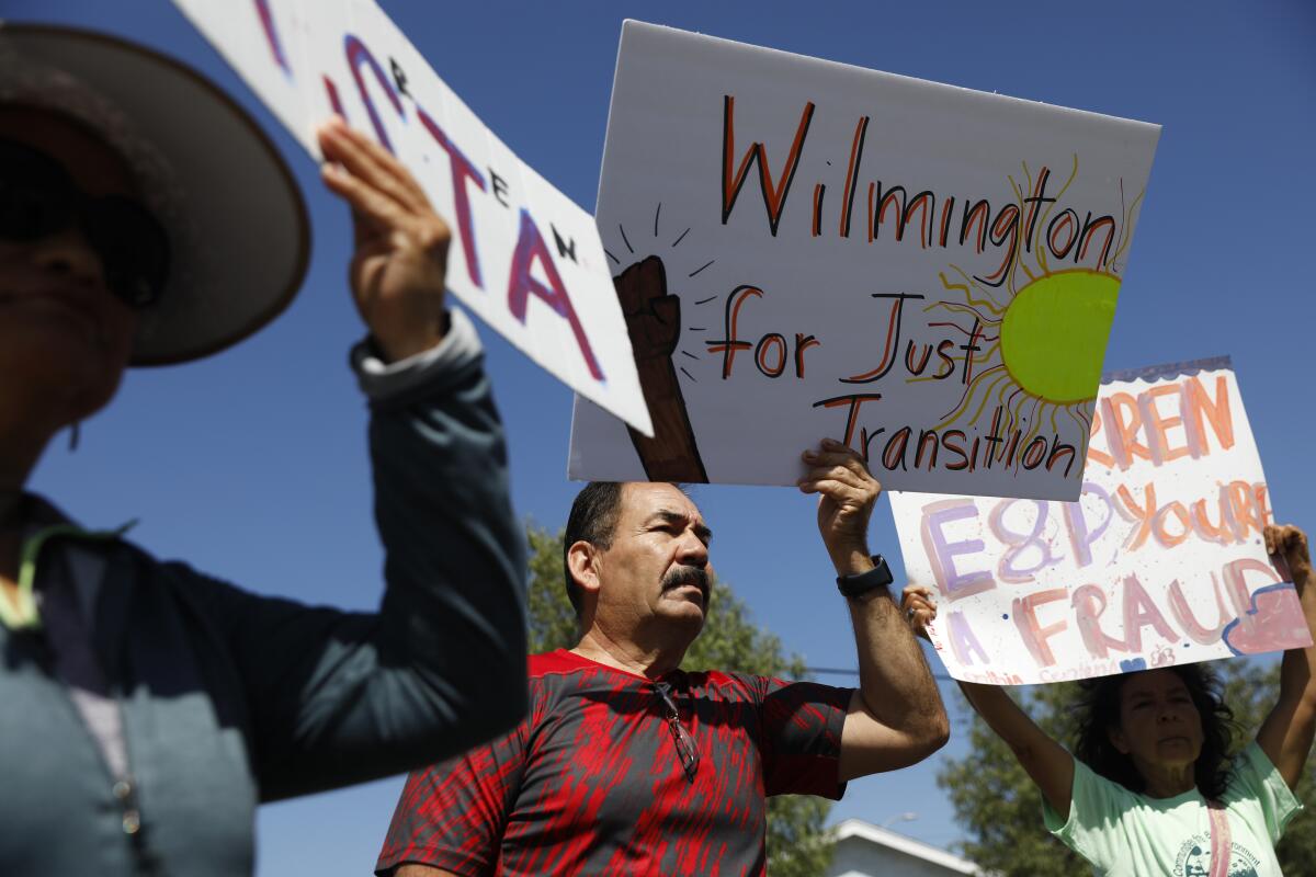 People hold up signs, including one that says "Wilmington for Just Transition."