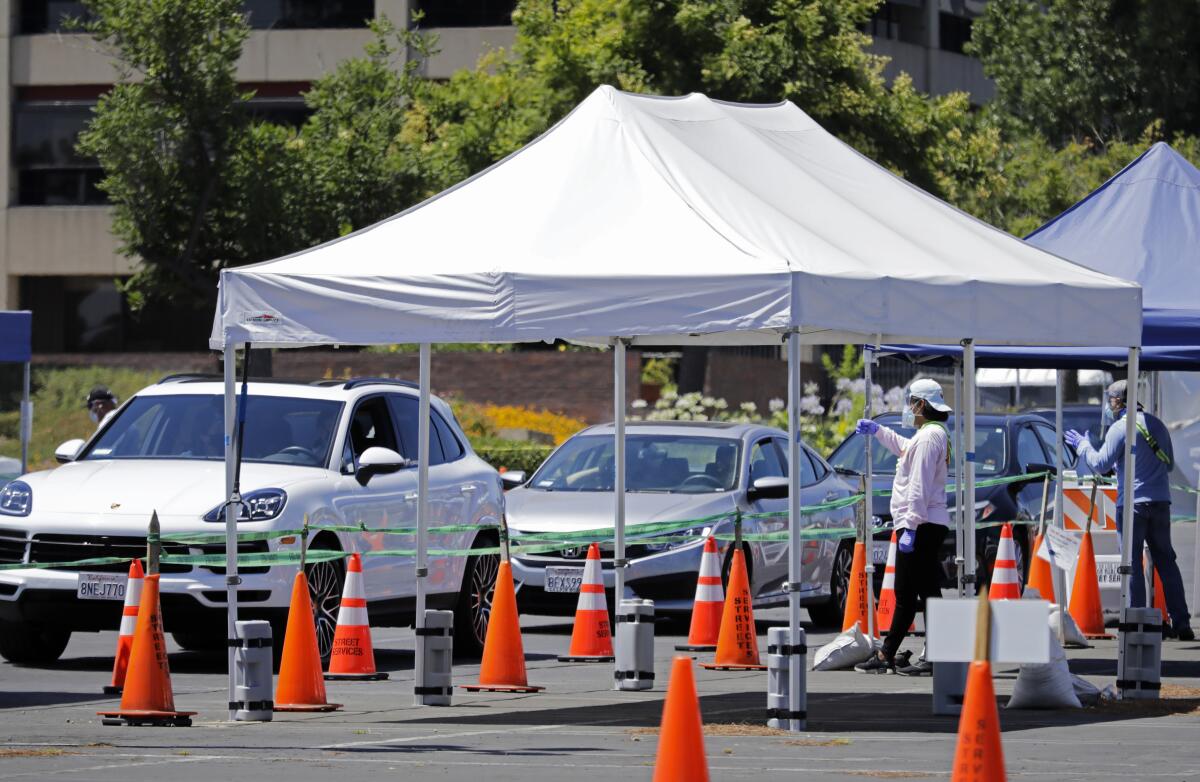 Cars line up at a drive-through coronavirus testing site.