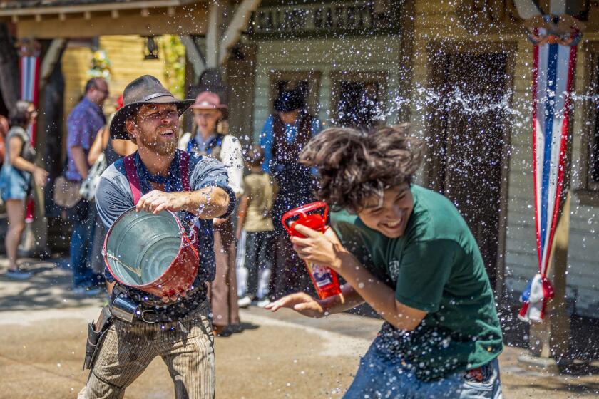 Alexis Rosales, of Bell gets drenched by Luke Brodowski, performing as Fluke Mayfield.