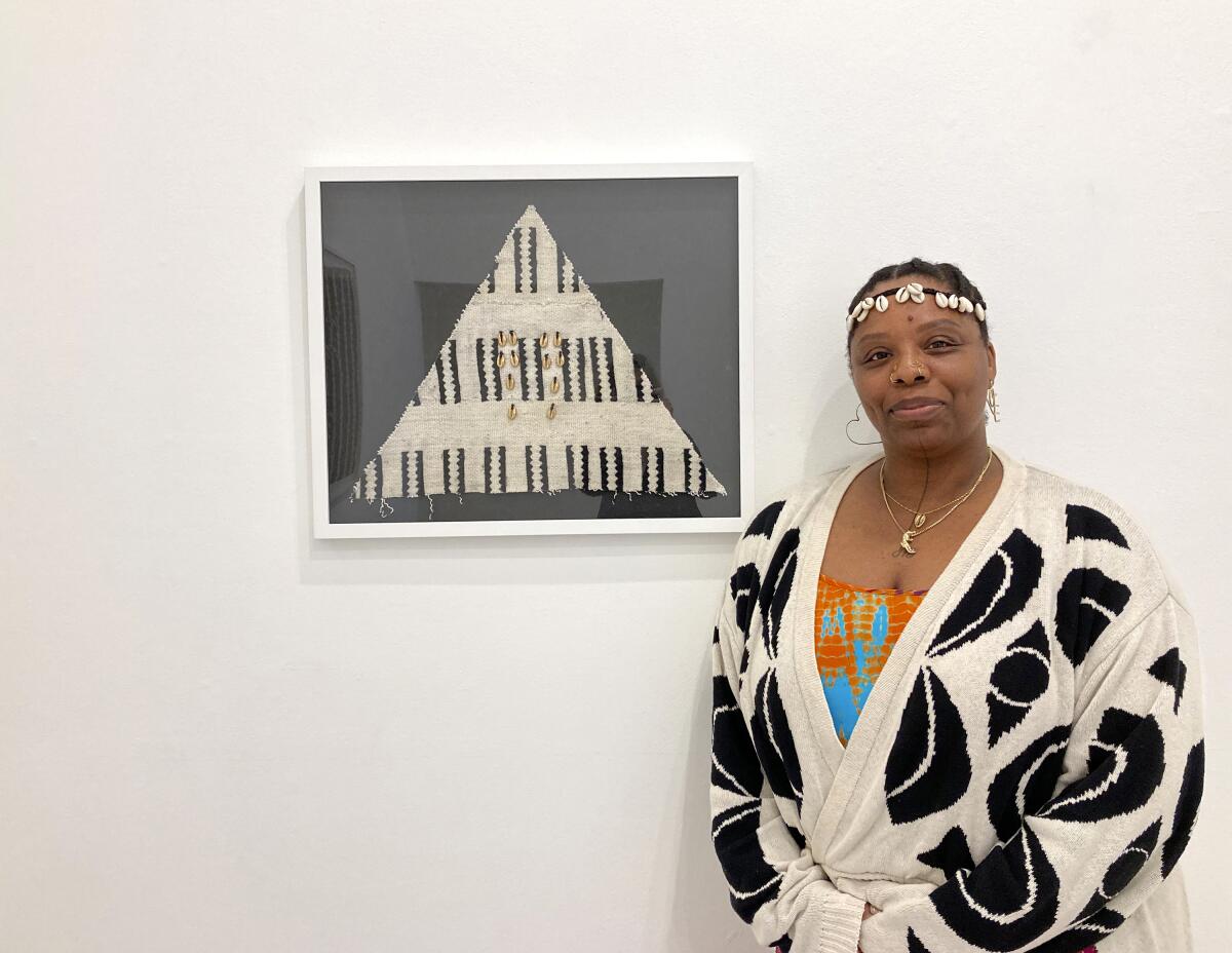 La artista y activista Patrisse Cullors junto a su obra hecha con textiles