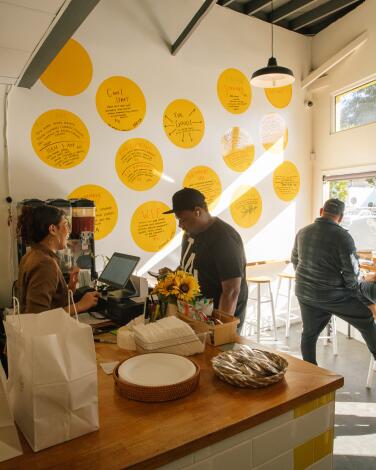 The menu at popular lunch spot Monroe Place is written on large yellow dots on the walls 