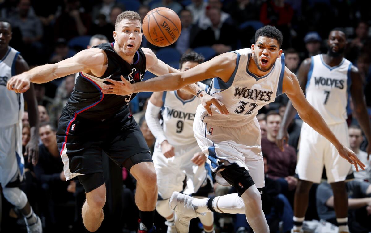 Clippers forward Blake Griffin Timberwolves center Karl Anthony Towns pursue a loose ball during the first half.
