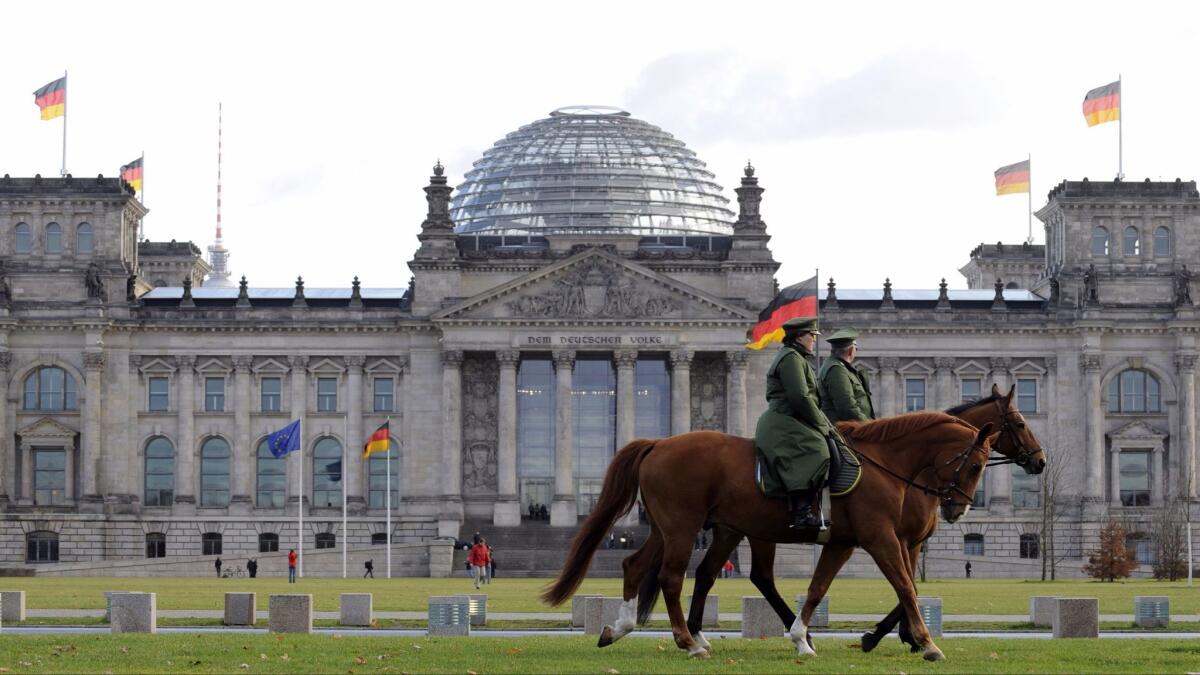 Police on horseback patrol in front of the Reichstag building, which houses Germany's lower house of parliament, in Berlin in 2009.