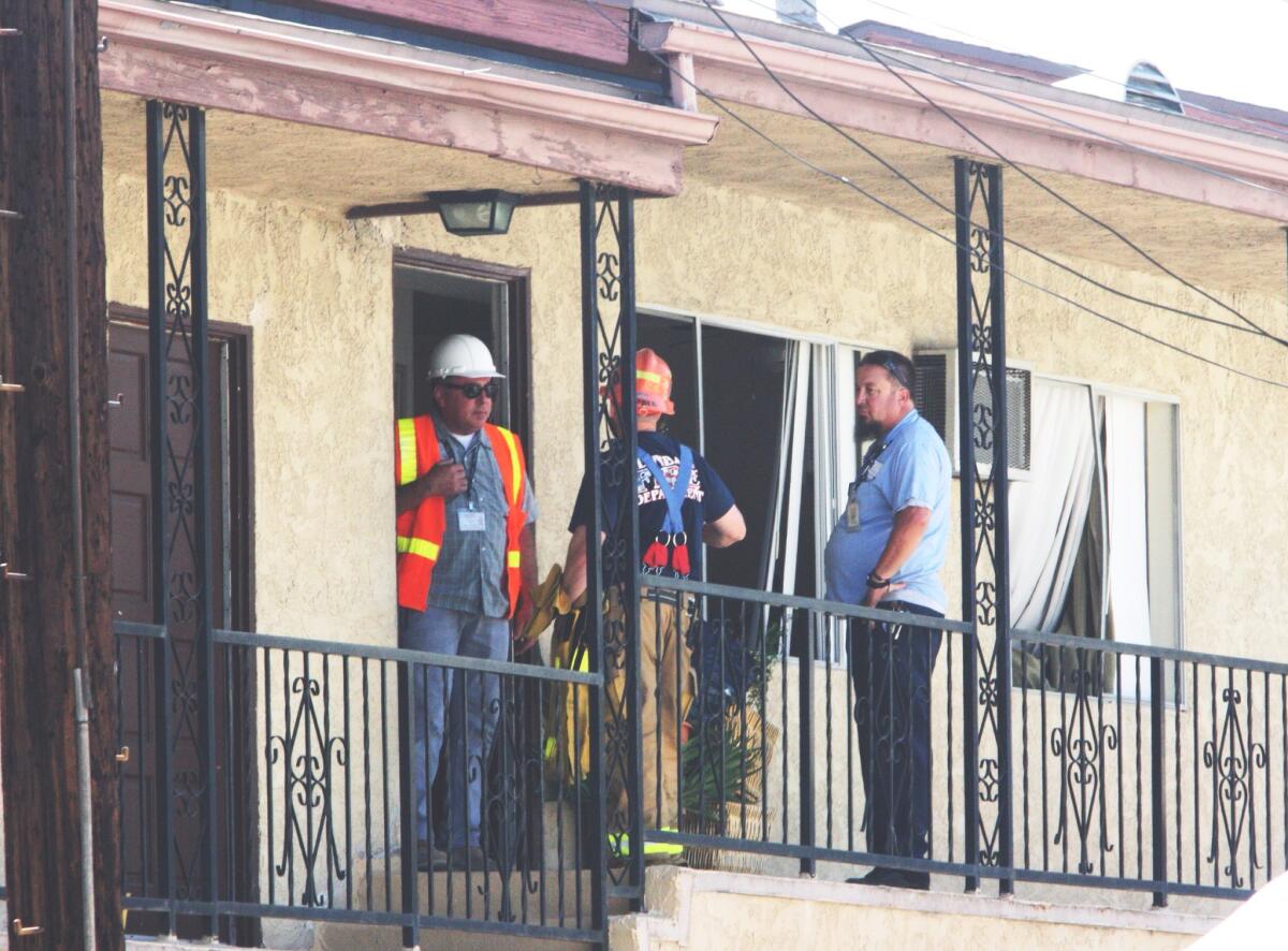 Emergency personnel confer outside a second story apartment at 4419 Pennsylvania Ave. in La Crescenta after an explosion on Friday, August 8, 2014.