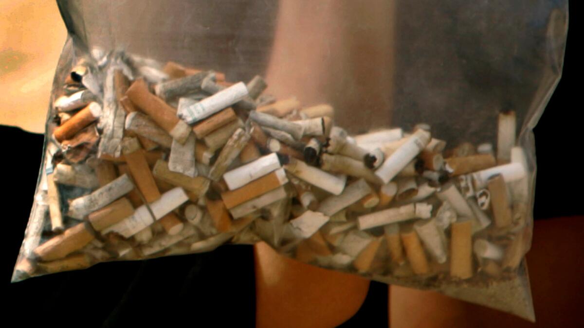 can you throw away unused cigarettes How to Stop Cigarette Butt Litter Throwing away cigarette hi-res stock