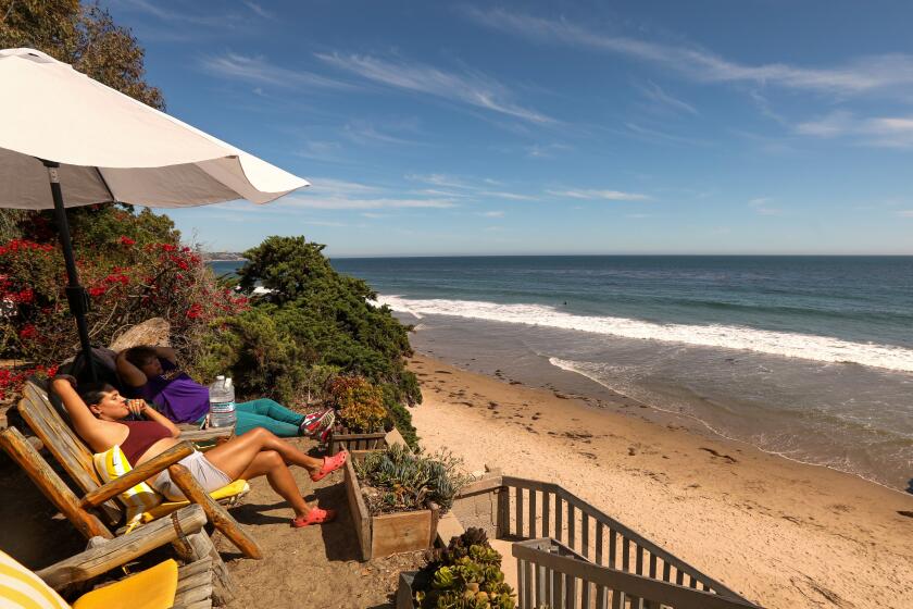 MALIBU, CA - AUGUST 10, 2022 - - Genesis Moreno, left, and her mother Karmen Gomez de Moreno look out over Lechuza Beach in Malibu on August 10, 2022. (Genaro Molina / Los Angeles Times)