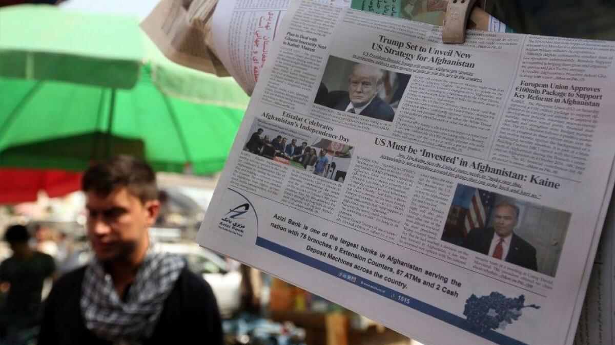 Newspapers hang for sale at a stand carrying headlines with photo of the U.S. President Donald Trump in Kabul, Afghanistan, Tuesday, Aug. 22, 2017. Reversing his past calls for a speedy exit, Trump recommitted the United States to the 16-year-old war in Afghanistan Monday night, declaring U.S. troops must "fight to win." (AP Photo/Rahmat Gul)
