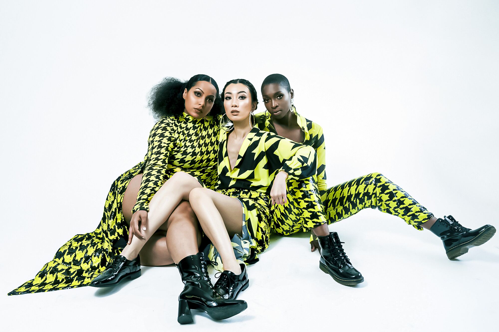 Three women wearing clothes covered in houndstooth checks.
