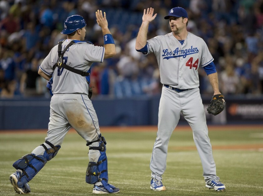 Dodgers catcher A.J. Ellis and pitcher Chris Withrow celebrate after the Dodgers' 14-5 victory over the Toronto Blue Jays on Monday.