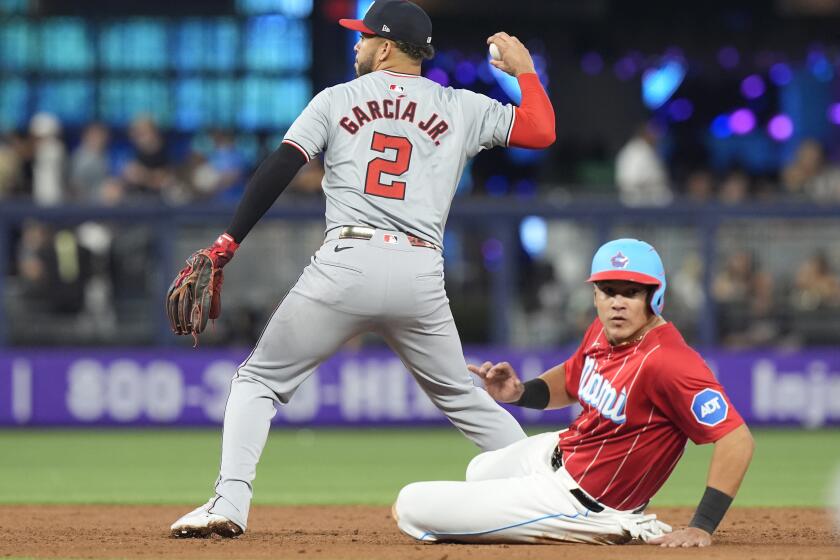 Miami Marlins' Avisaíl García is forced out on second base as Washington Nationals second baseman Luis García Jr. (2) looks to throw to third base during the third inning of a baseball game, Saturday, April 27, 2024, in Miami. (AP Photo/Marta Lavandier)