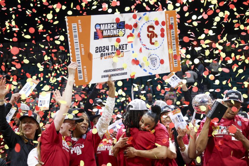 USC freshman JuJu Watkins embraces a teammate as the Trojans celebrate winning the Pac-12 tournament title 