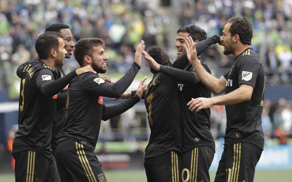 Los Angeles FC forward Diego Rossi, third from left, celebrates with teammates after he scored a goal against the Seattle Sounders during the first half of an MLS soccer match, Sunday, March 4, 2018, in Seattle.