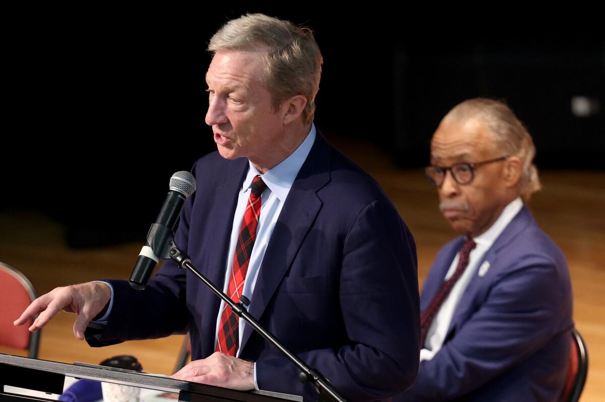 Democratic presidential candidate Tom Steyer speaks as the Rev. Al Sharpton looks on Wednesday at a breakfast in North Charleston, S.C.