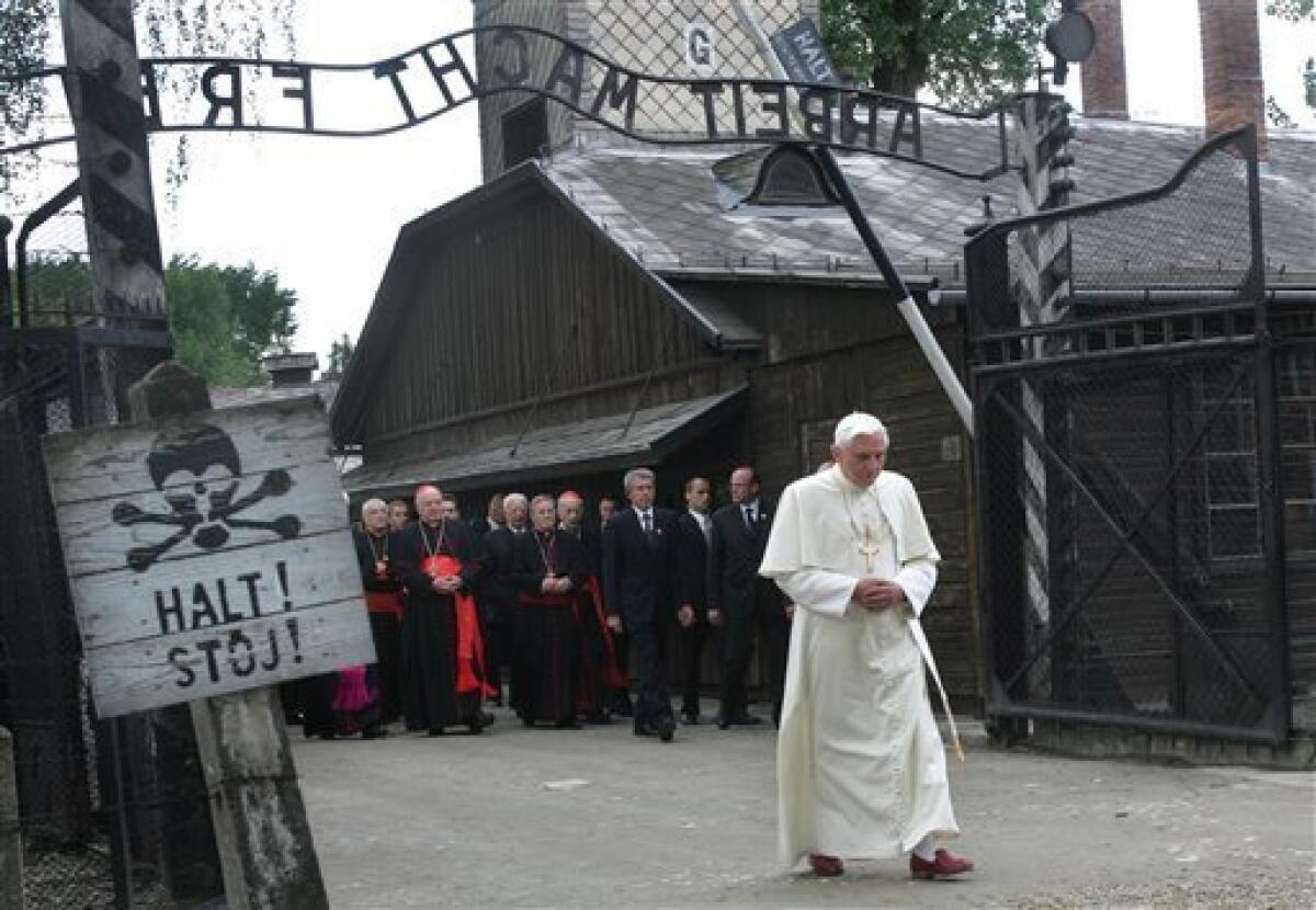 FILE - In this May 28, 2006 file photo Pope Benedict XVI walks through the gate of the former Nazi concentration camp Auschwitz in Oswiecim, Poland, to pay his respects to the Holocaust victims. Sign at left reads "Stop" in German and Polish. Sign above the gate reads "Arbeit macht frei," German for "Work Sets Yoe Free" Polish police say the infamous iron sign over the gate to the Auschwitz memorial site with the cynical phrase "Arbeit Macht Frei" _ German for "Work Sets You Free" _ has been stolen. Police spokeswoman Katarzyna Padlo said police believe it was stolen between 3:30 a.m. and 5 a.m. Friday, Dec. 18, 2009, when museum guards noticed that it was missing and alerted police. (AP Photo/Diether Endlicher, File)