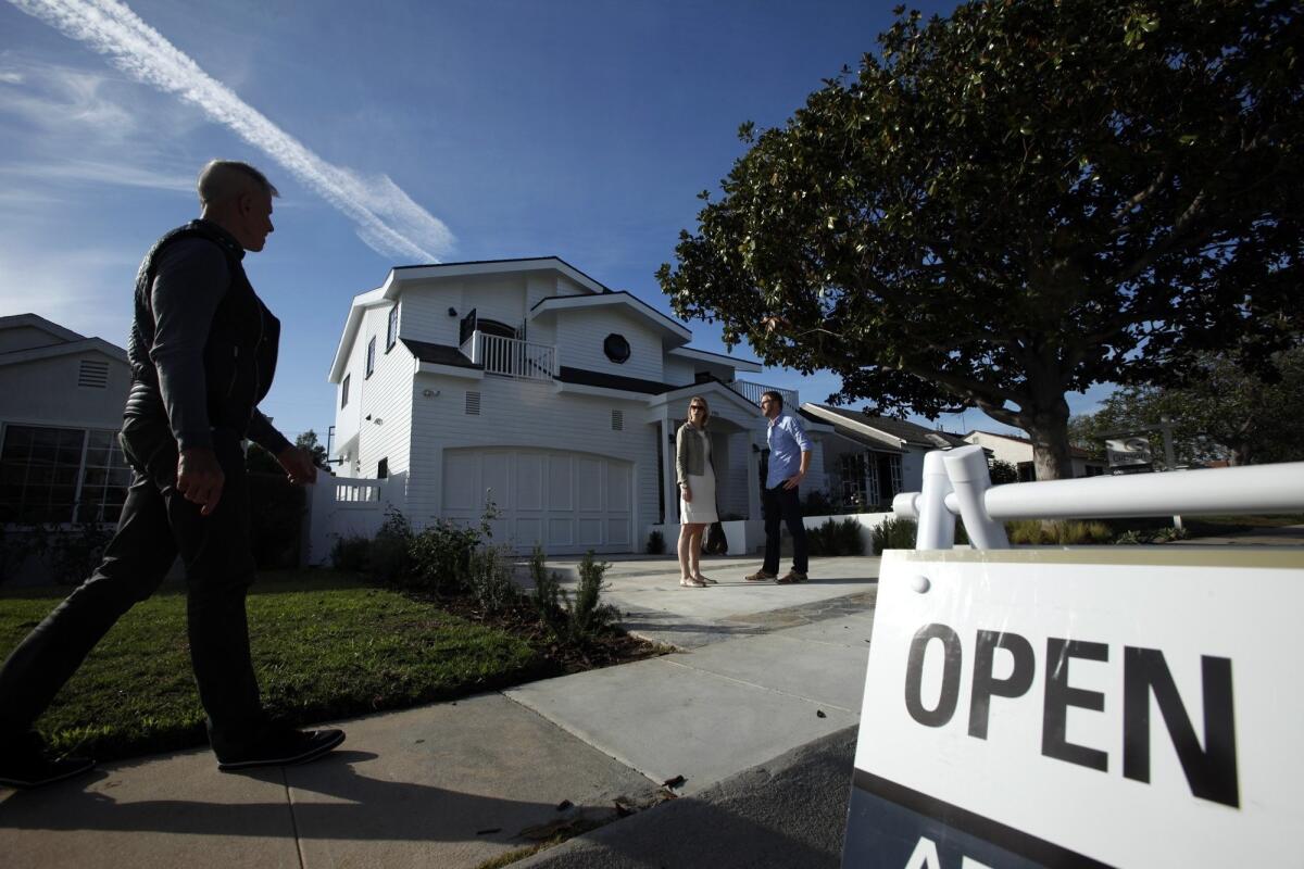 Prospective home buyers Theresa and Dustin Dobson wait for their real estate agent, Jim Crane, left, before checking out a home in Westchester in December.