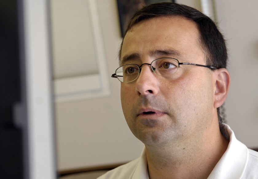 FILE - In this July 15, 2008, file photo, Dr. Larry Nassar works on the computer after seeing a patient in Michigan. Nassar, a former USA Gymnastics team doctor, was charged Monday, Nov. 21, 2016, with first-degree criminal sexual conduct in Michigan involving a child under 13. (Becky Shink/Lansing State Journal via AP, File)