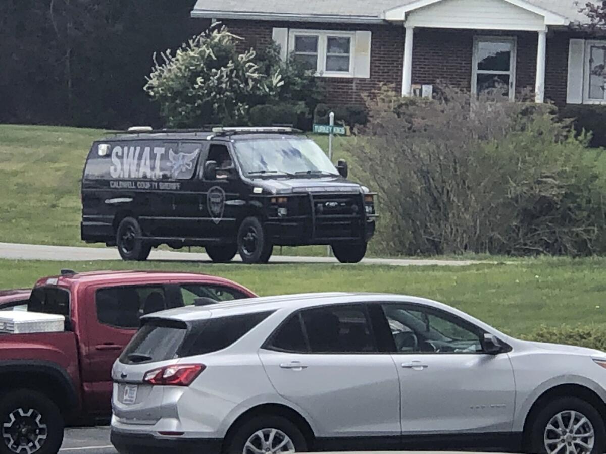 In this photo provided by WJZY, a tactical van from Caldwell County, North Carolina, sits on stand-by at a staging area in Boone, N.C., on Wednesday, April 28, 2021. Law enforcement agencies responded to a standoff in Boone in which two Watauga County sheriff’s deputies were shot and wounded. (Morgan Frances/WJZY via AP)