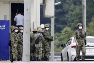 Japanese Self Defense Force members gather near a facility in a base firing range, following a deadly shooting in Gifu, central Japan, Wednesday, June 14, 2023. A Japanese soldier was arrested Wednesday after allegedly shooting three colleagues at an army base in central Japan, officials said. (Kyodo News via AP)