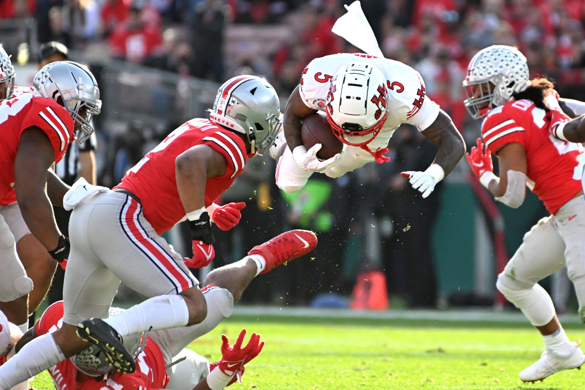  Utah running back T.J. Pledger goes airborne after being upended by the Ohio State defense.