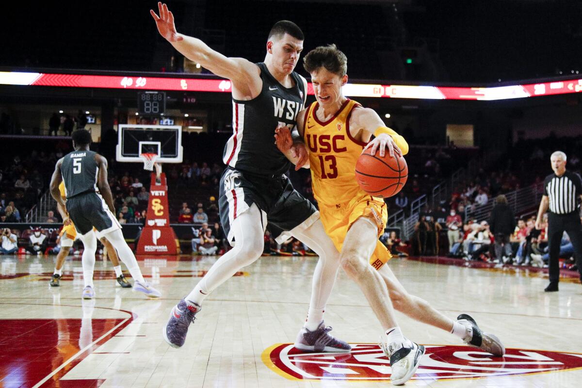 USC guard Drew Peterson, right, drives on Washington State forward Andrej Jakimovski during the first half Thursday.