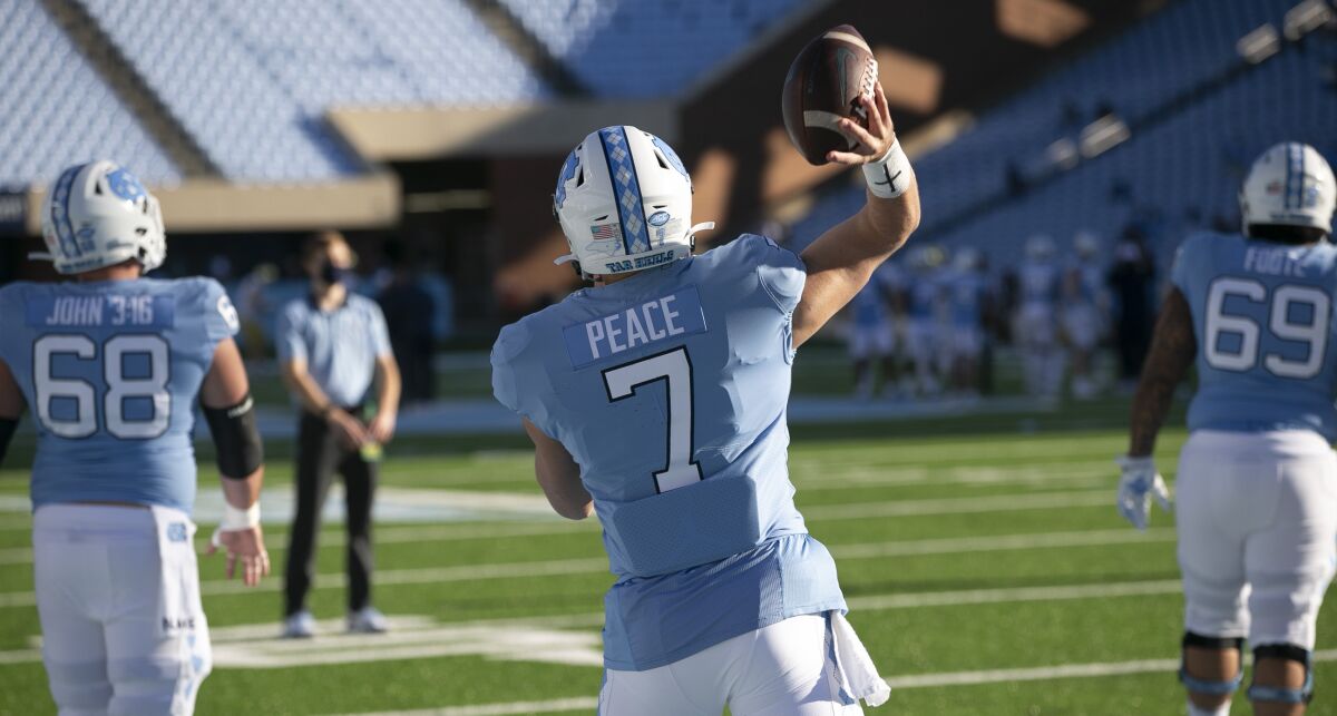 North Carolina quarterback Sam Howell (7) has replaced his last name with 'Peace" on the back of his game jersey as he warms up for the Tar Heels' game against Notre Dame on Saturday, November 27, 2020 at Kenan Stadium in Chapel Hill, N.C. Several players has done the same, choosing other messages for this particular game. (Robert Willett/The News & Observer via AP)