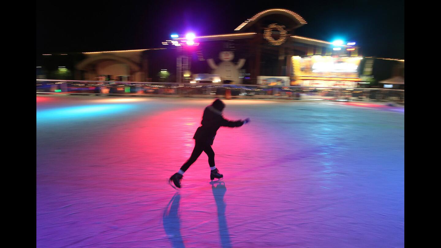 An ice skater takes to the rink under the lights moments before the masses arrive during the 3rd annual Winter Fest OC at the OC Fair & Event Center on Thursday.