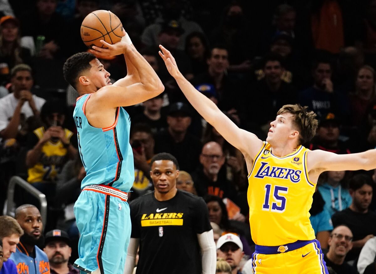 Phoenix Suns' Devin Booker shoots a three pointer against Lakers' Austin Reaves.