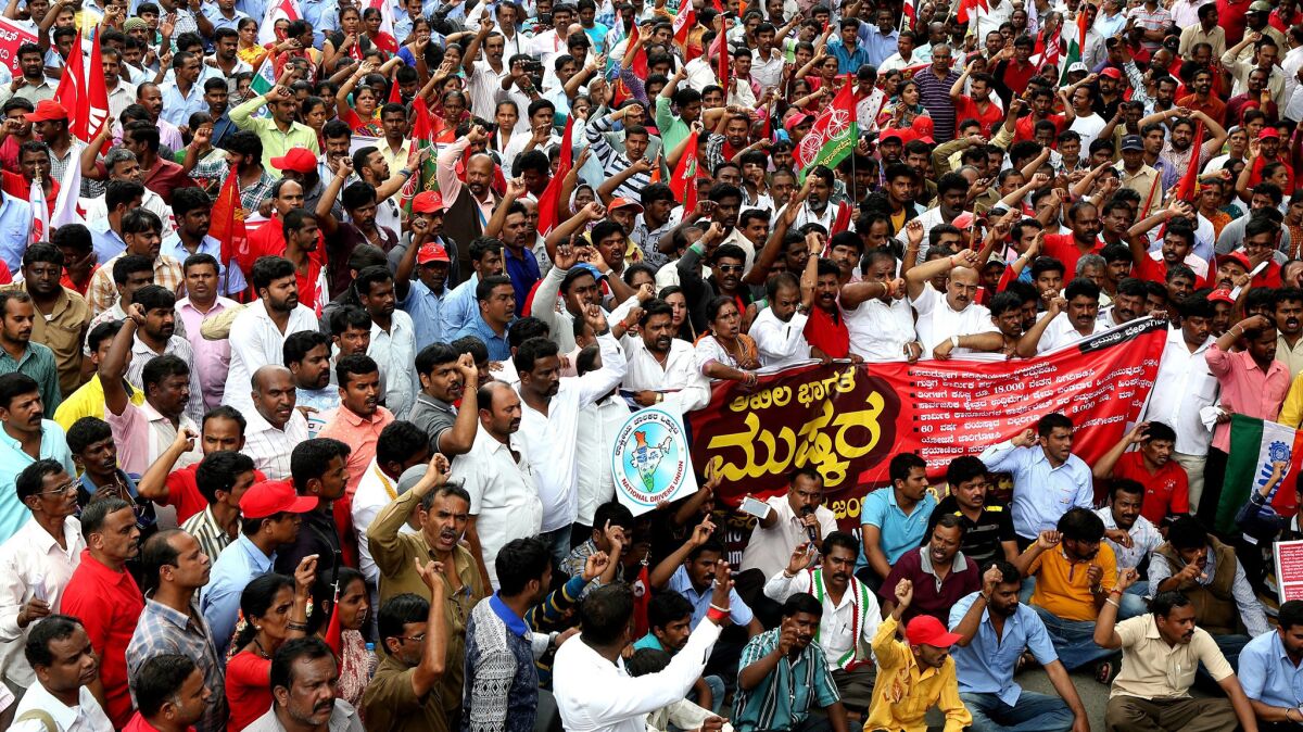 Members of different trade unions hold placards and shouts slogans against the Bharatiya Janata Party in Bangalore, India.