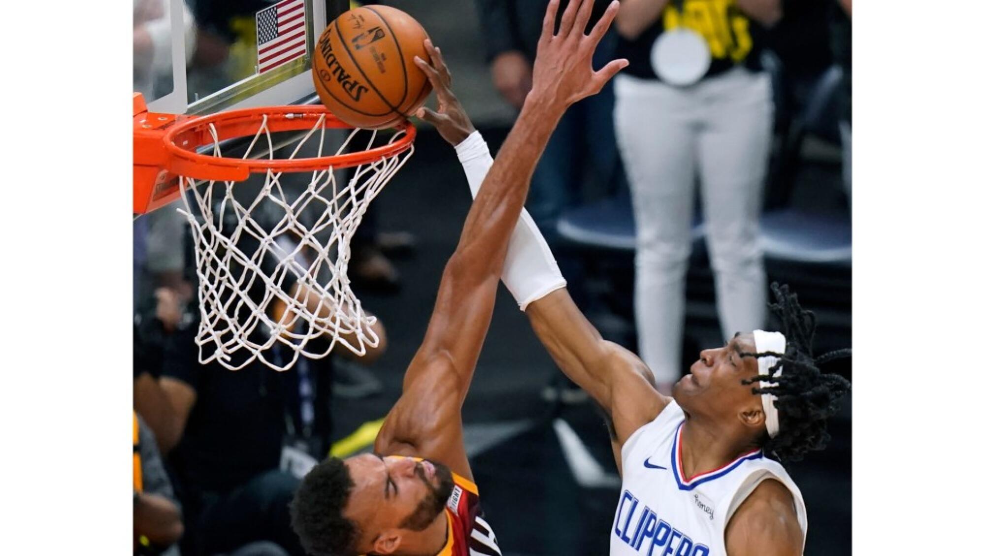 Clippers guard Terance Mann dunks over Jazz center Rudy Gobert during a playoff game June 16, 2021.