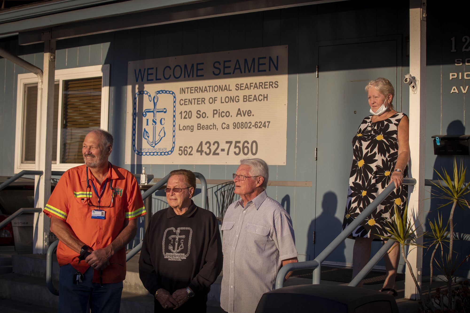 This photo shows four people standing in front of the International Seafarers Center