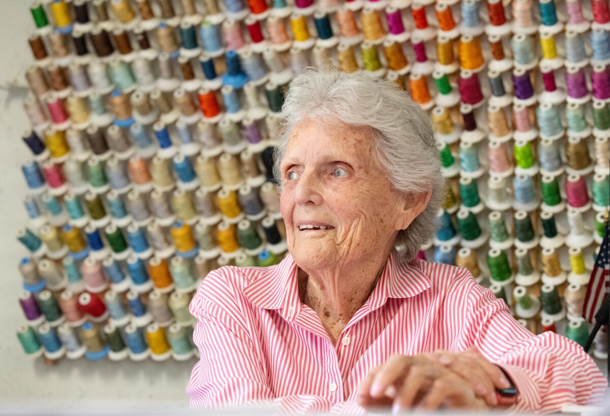 Barbara "Corki" Rawlings stands in front of thread at her embroidery shop in Newport Beach.