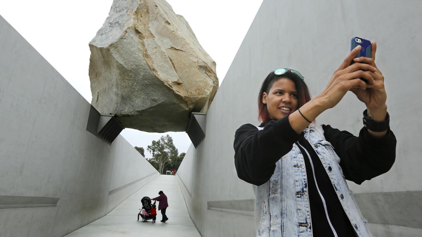 Monica Carter of Chicago takes a selfie in front of the "Levitated Mass" boulder sculpture at the Los Angeles County Museum of Art in Los Angeles.